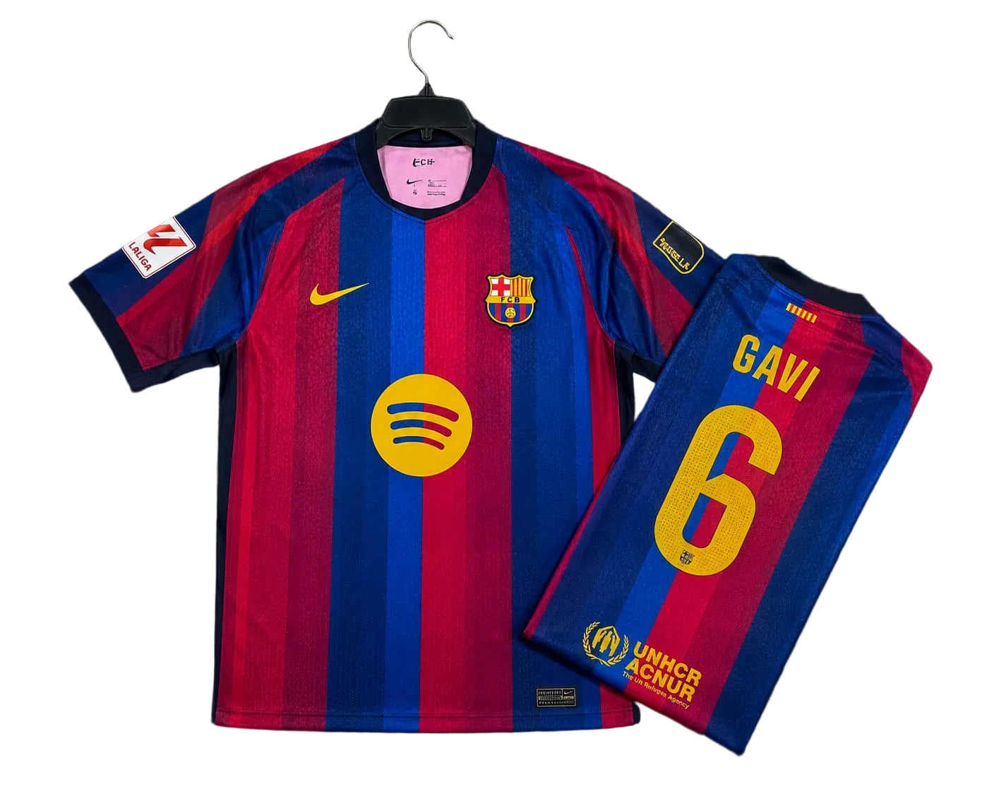 FC Barcelona home soccer jersey by Nike, featuring blue and red vertical stripes with yellow accents, shown as both front and back views on a black background.